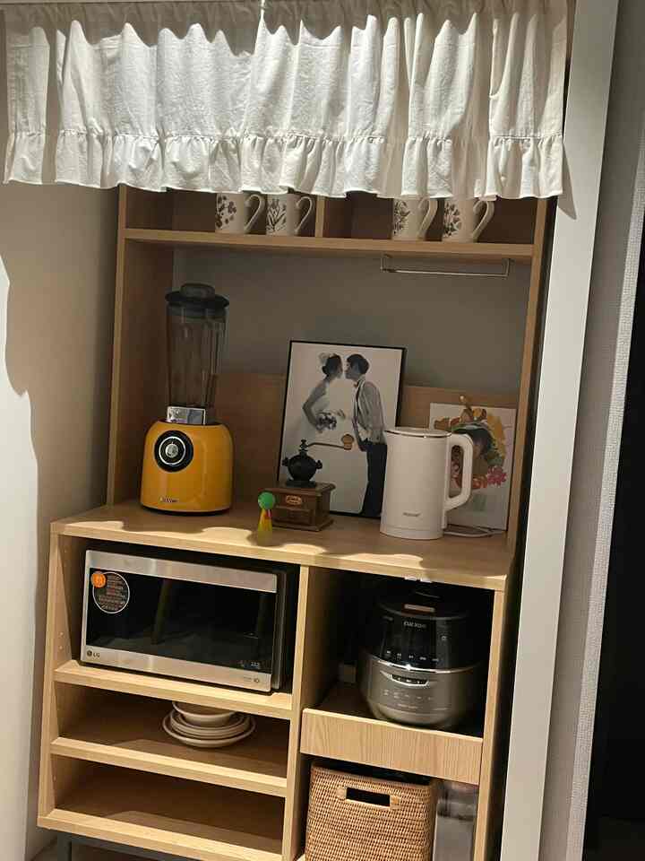 Beige and white toned kitchen cafe cabinet with blender and microwave, creating a cozy natural style space
