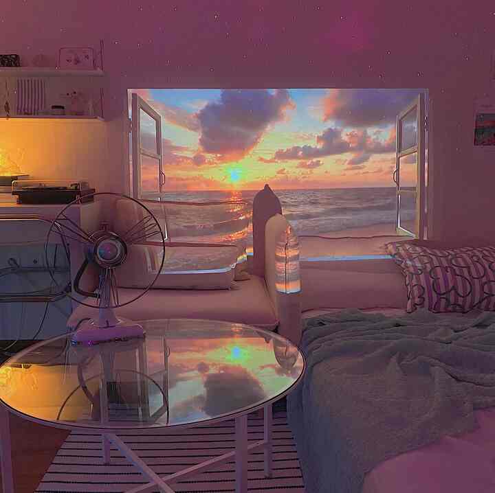 ホワイトと淡いパステル調のワンルーム、ギャラクシープロジェクターとヴィンテージ扇風機、ガラスのコーヒーテーブルが配された雰囲気のあるインテリア