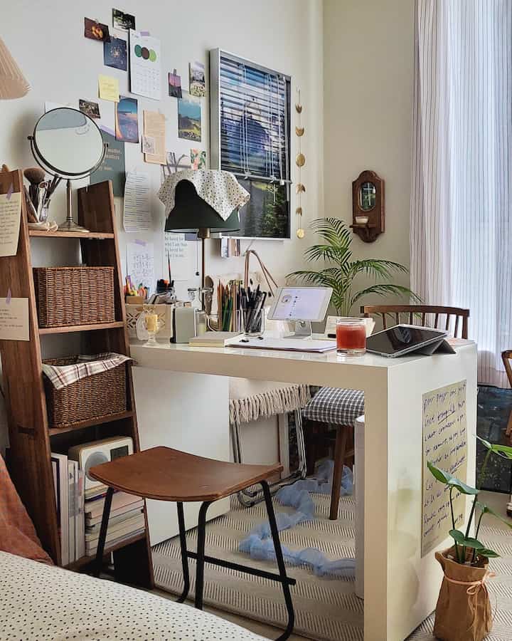 Bright white and wood-toned small studio home office with desk, plants, and blinds creating a warm workspace