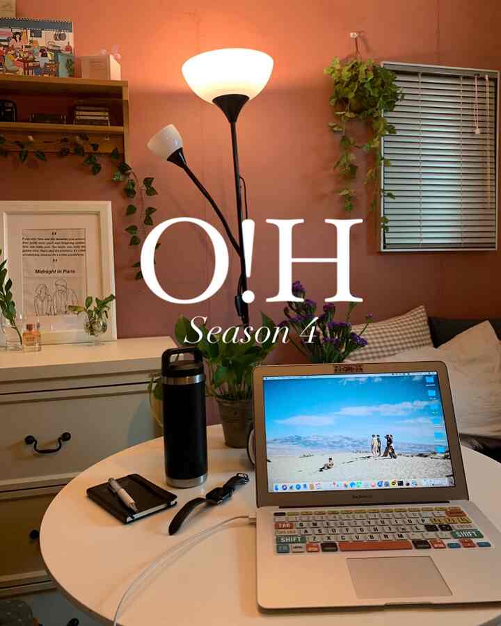 Cozy bedroom with warm brown-toned walls and white furniture, featuring a round table with a laptop and a floor lamp