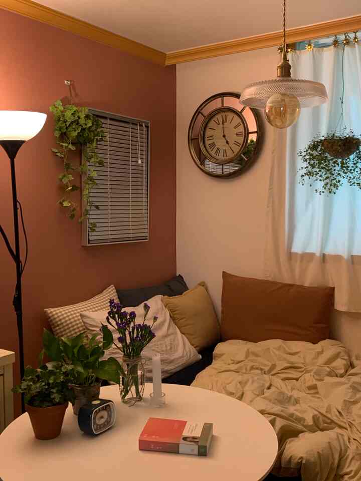 Beige and brown toned bedroom featuring a round table and various plants with a cozy, natural atmosphere