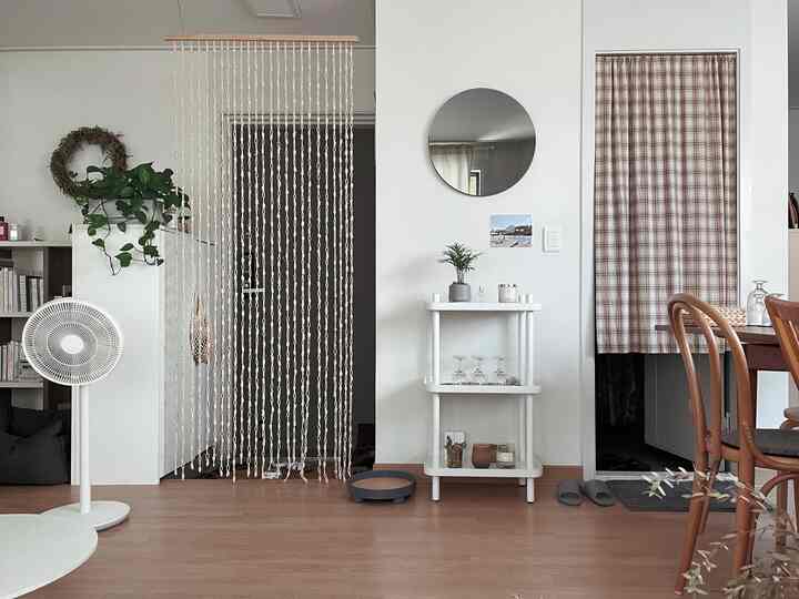 White and wood-toned entrance space featuring check curtain and string curtain with cozy atmosphere