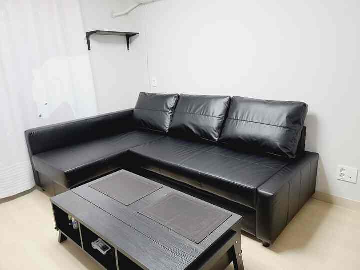 Modern living room in black and white tone featuring a corner sofa and coffee table in a compact space