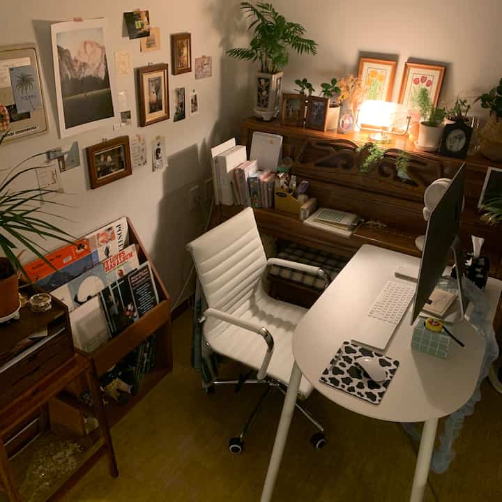 Cozy home office space with warm lighting, vintage wooden piano, white desk and office chair arranged