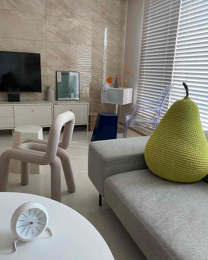 Modern living room in gray and white tones featuring wood blinds and stylish chairs with a clean atmosphere
