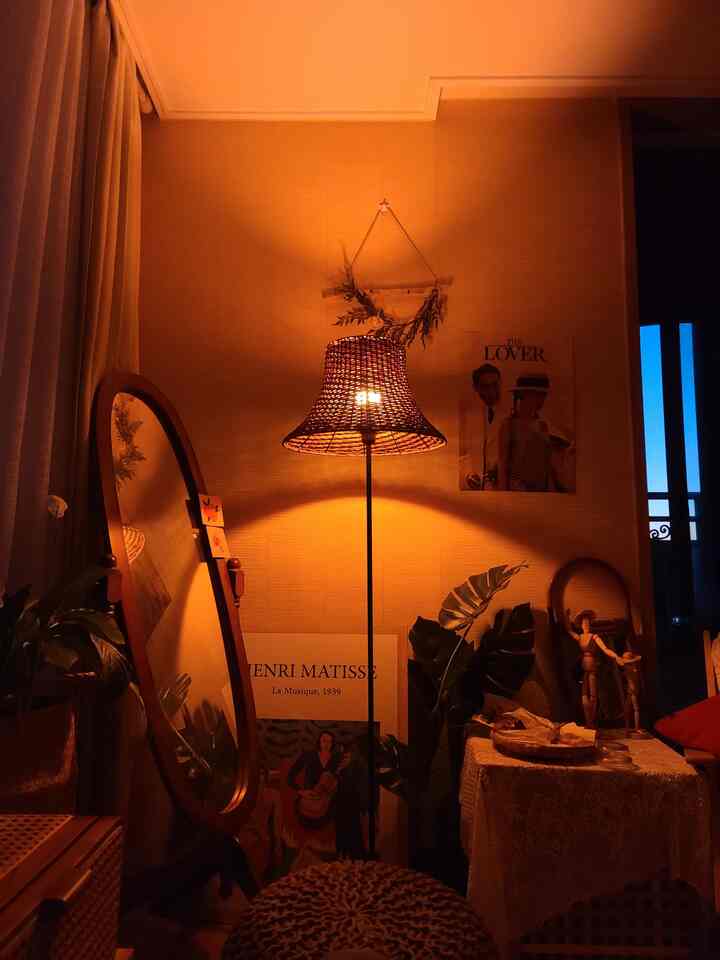 Warm beige and brown toned studio featuring rattan floor lamp and full-length mirror with cozy home cafe vibe