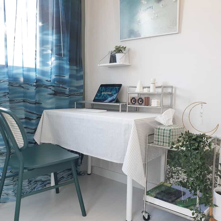 White and blue toned study space featuring a desk, monitor stand, and tablecloth with a modern interior