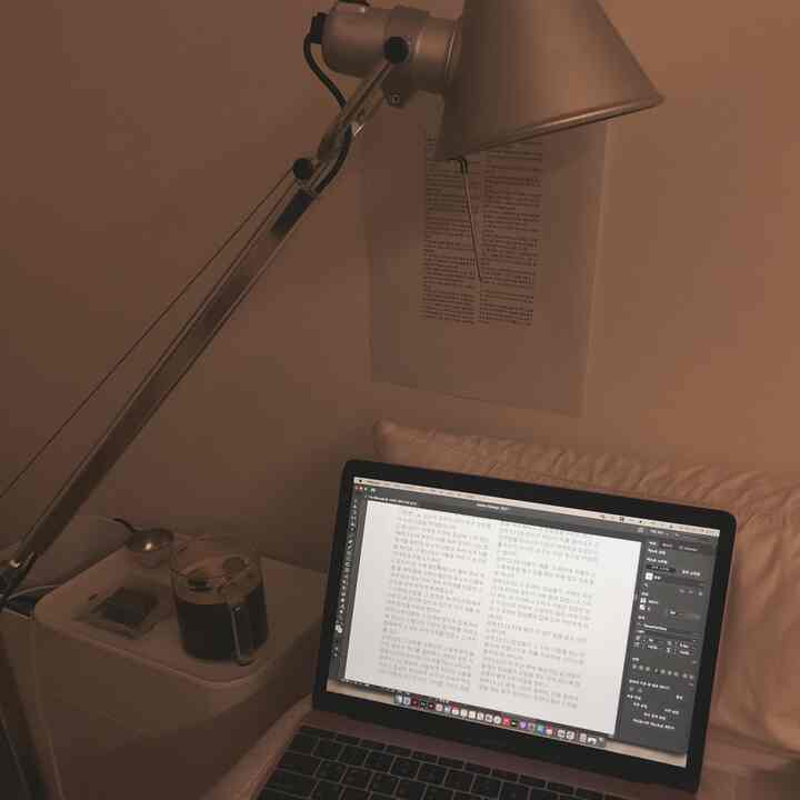 Warm brown and white toned home office featuring a side table with coffee cup and a MacBook laptop, creating a cozy remote work setup