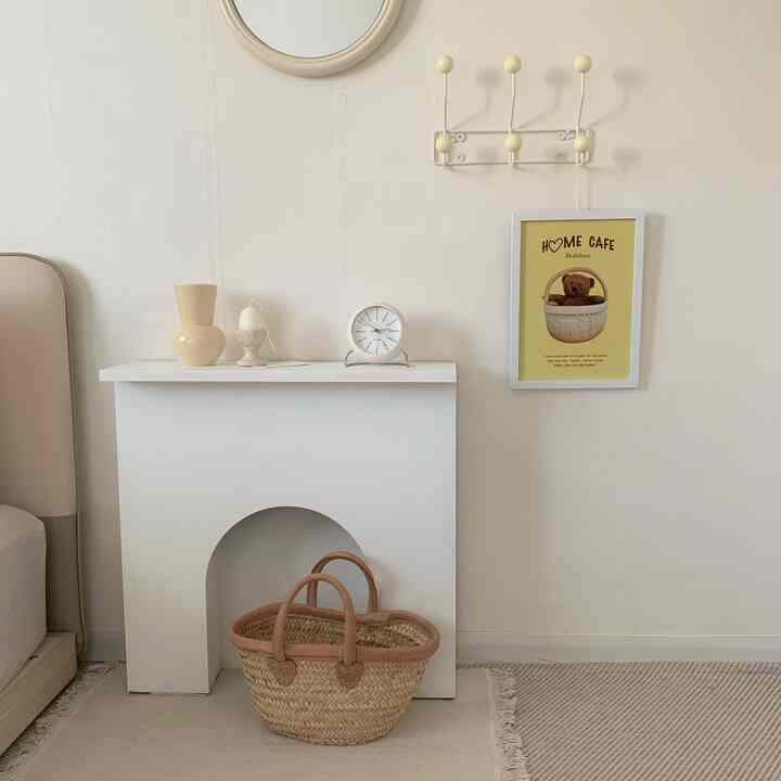 Cozy living room with warm ivory and natural wood tones featuring a white fireplace console and a bear-themed interior poster