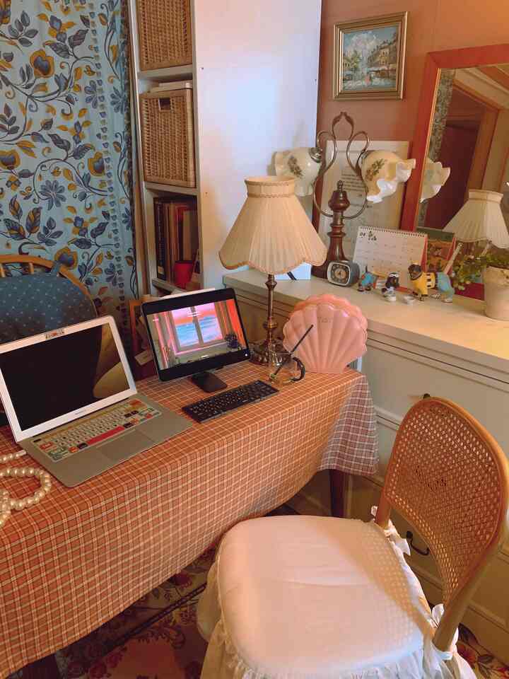 A cozy home office in brown and beige tones featuring a vintage desk and rattan chair with warm accessories