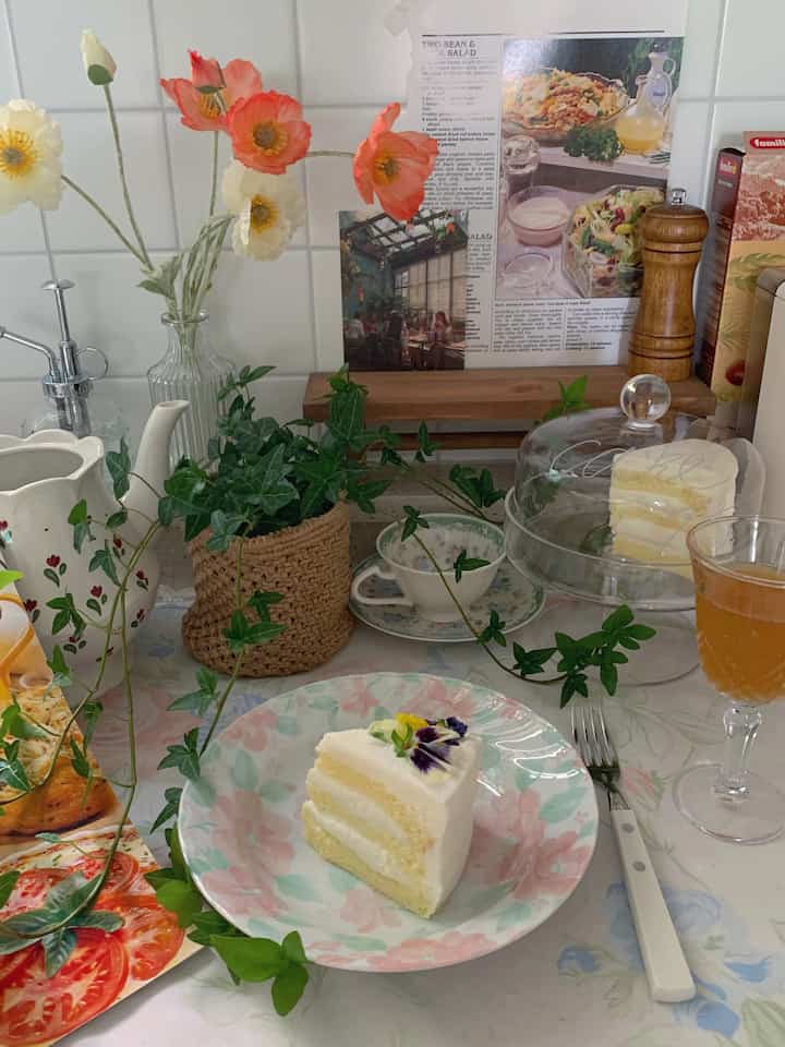 白いタイルの背景に花瓶やデザート皿が配置された、居心地の良いキッチンのホームカフェ空間
