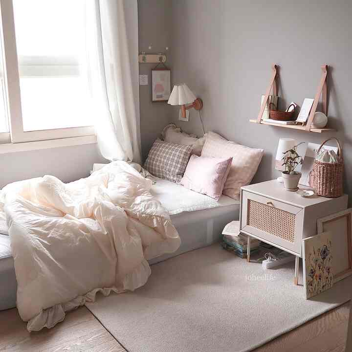 ホワイトとグレーのナチュラルトーンの寝室、ベッドとナイトテーブル、壁の棚が配置された印象的な空間