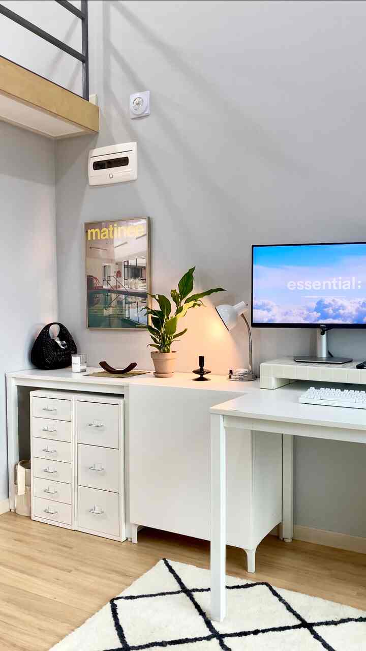 Bright white and natural wood tone study-style home office featuring desk with plant and table lamp