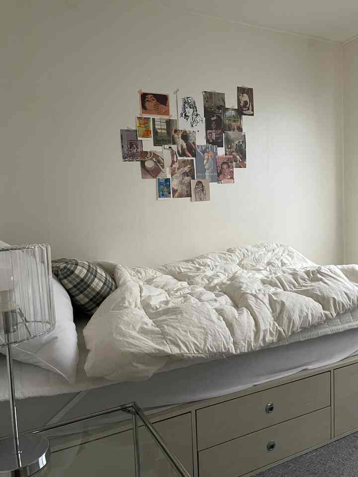 White-toned bedroom space featuring storage bed and wall decor with a simple, modern atmosphere