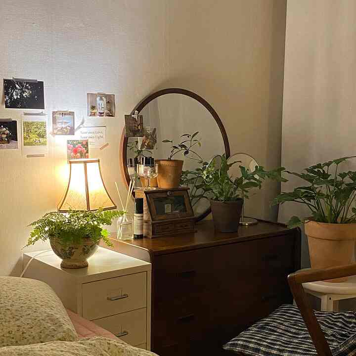 暖かい黄色の照明と木製家具、植物が配置された雰囲気のあるヴィンテージ風の居心地の良い寝室