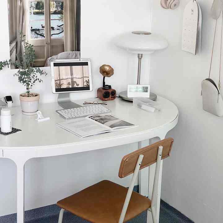 White and brown toned home office featuring a clean desk and office chair in a modern setting