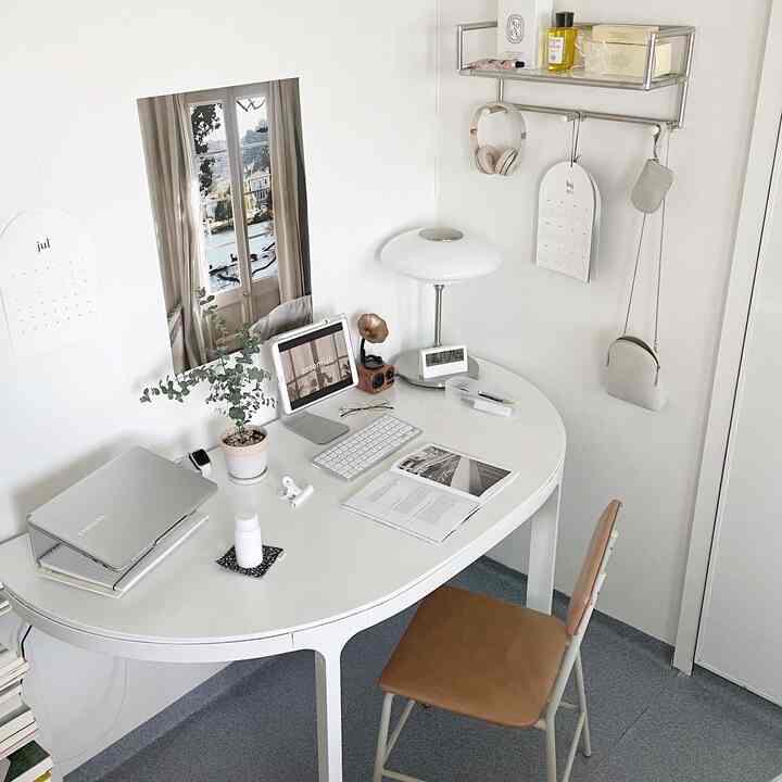 White and brown toned home office space featuring a curved desk and practical office chair in a modern atmosphere