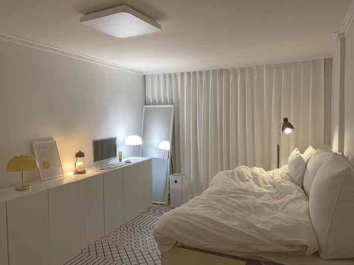 Bright white-toned bedroom featuring built-in closet and bed with simple and modern interior design