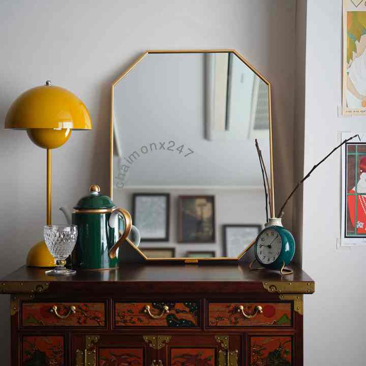 Natural toned living room with yellow table lamp and antique furniture featuring a wall mirror
