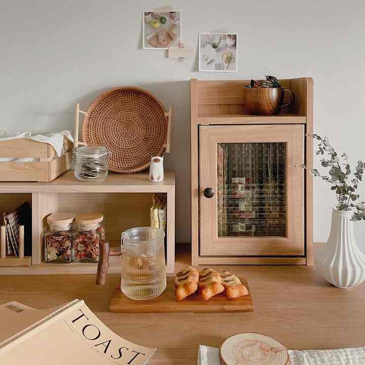 Beige and wood tone kitchen space featuring a rattan tray and storage cabinet creating a cozy home cafe atmosphere
