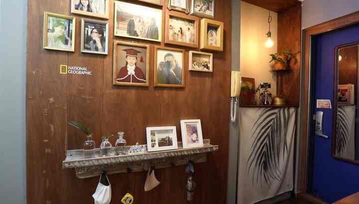 Wood tone entrance featuring multiple photo frames on the wall, rustic shelf with decorative items, creating a cozy vintage atmosphere