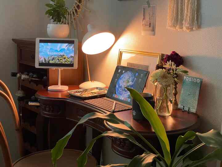 暖かいブラウン調の書斎、木製のデスクと椅子にアイパッドとテーブルランプが配置された雰囲気のあるホームオフィスインテリア