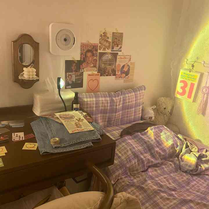 Cozy bedroom with soft purple bedding and vintage posters creating warm ambiance