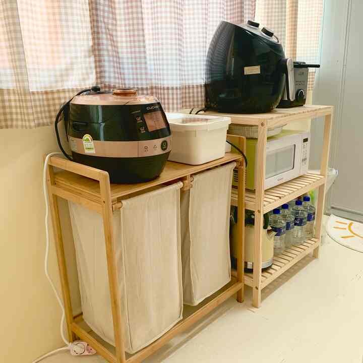 Natural wood-tone kitchen space featuring wooden shelves holding various kitchen appliances and storage containers, creating a tidy atmosphere
