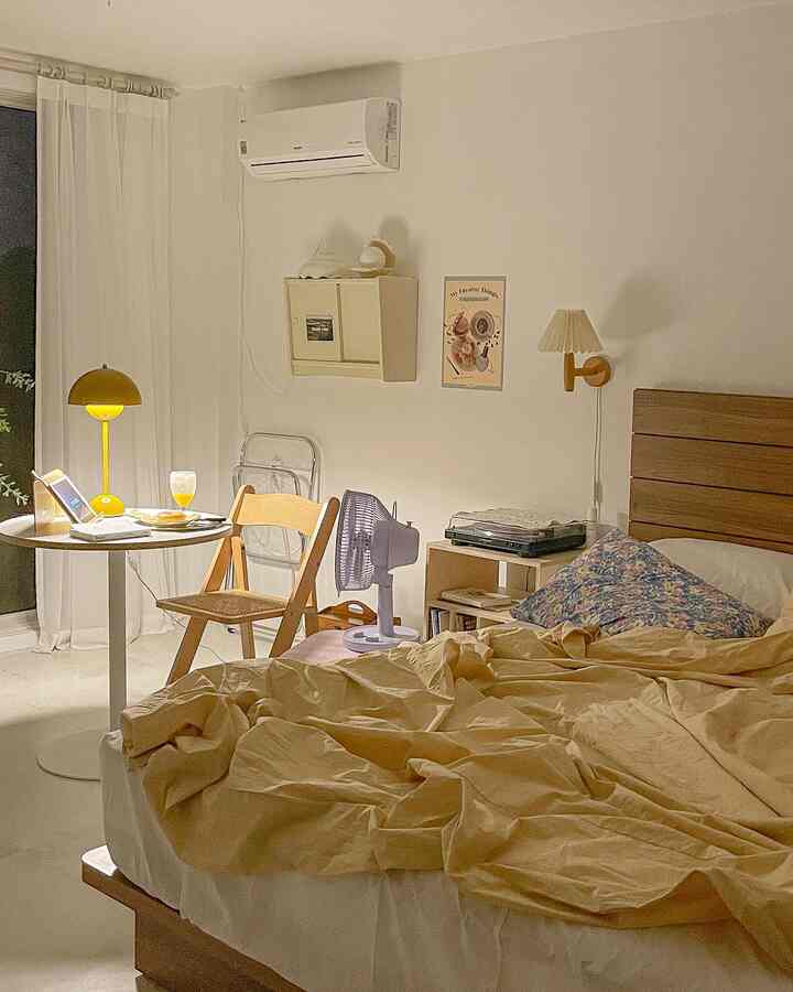 Ivory and warm yellow toned bedroom with wooden bed and round table, cozy and natural atmosphere