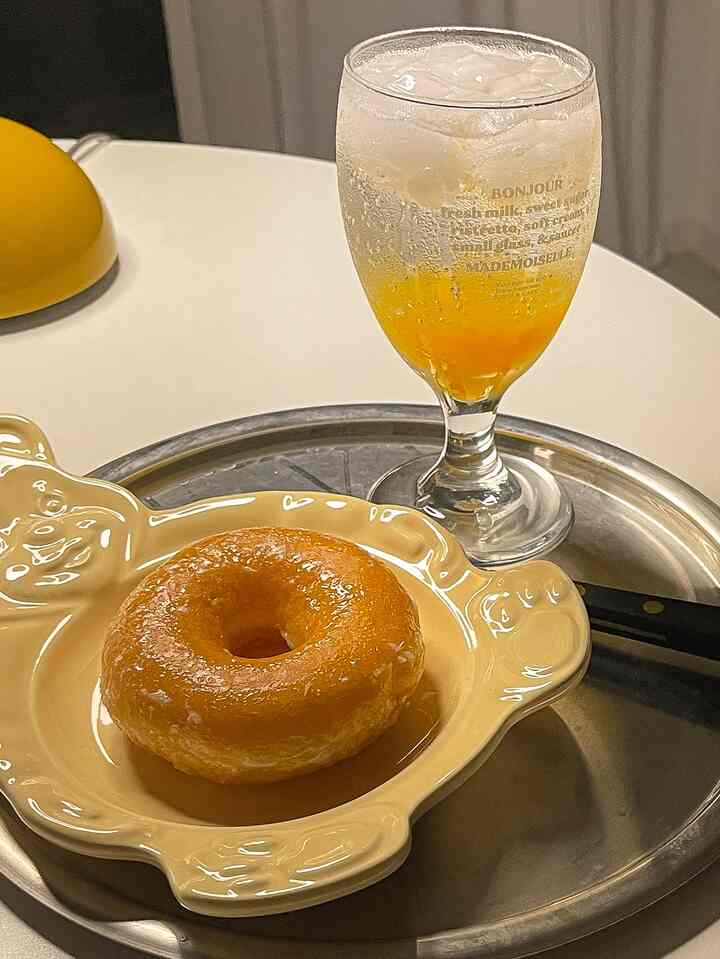 Yellow and silver round table featuring a bear-shaped plate with a donut and iced beverage in a cozy home cafe setting