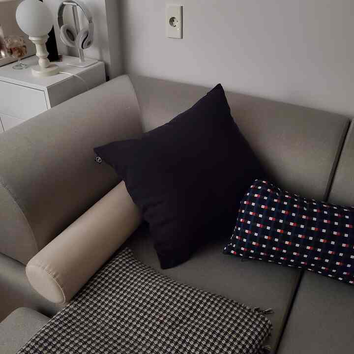 Monotone living room sofa featuring various cushions arranged neatly, creating a cozy atmosphere