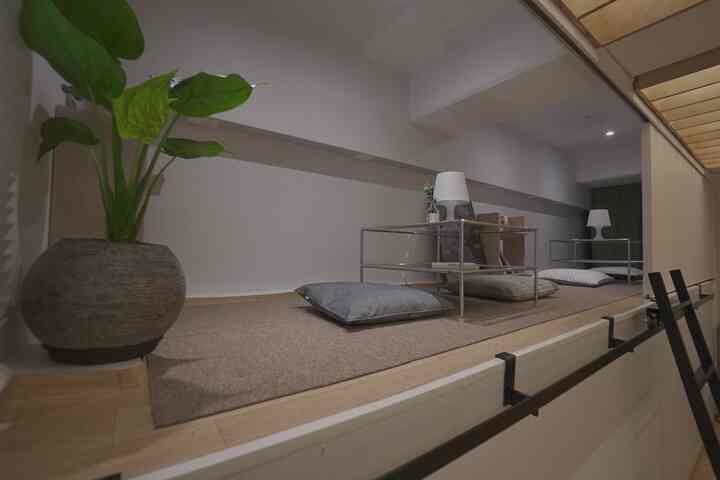 Beige and white toned compact loft space featuring floor cushions and metal frame side tables with a cozy atmosphere