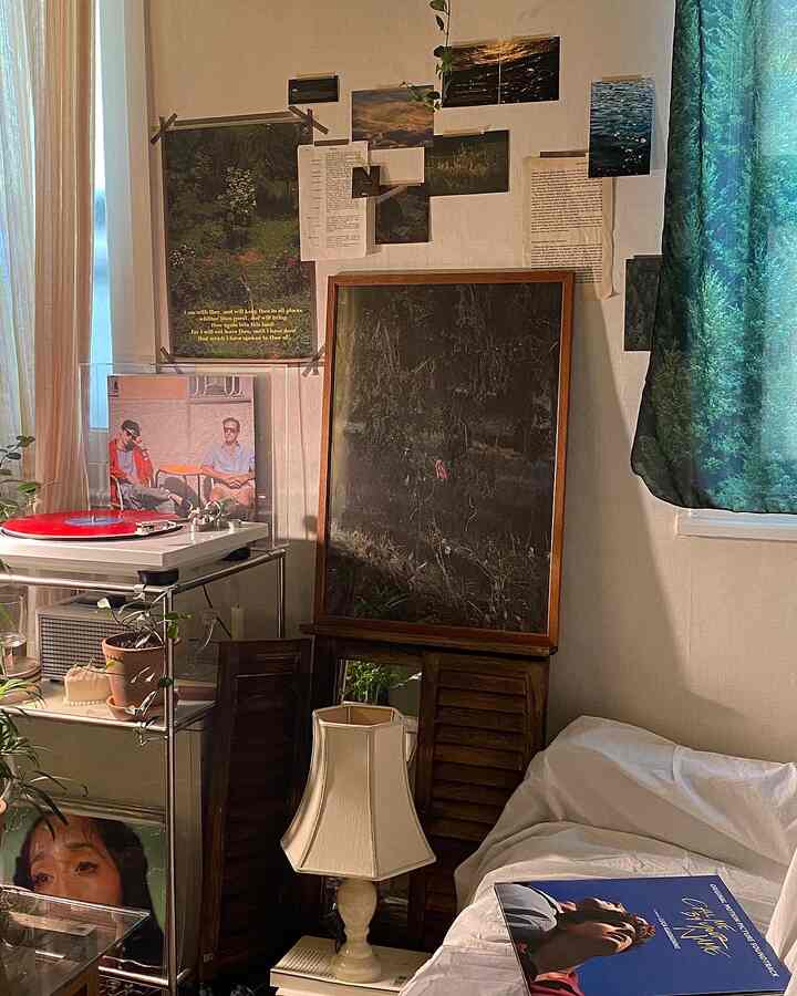 暖かいベージュトーンのワンルーム、ヴィンテージの額縁とターンテーブル、植物が配置された印象的な空間