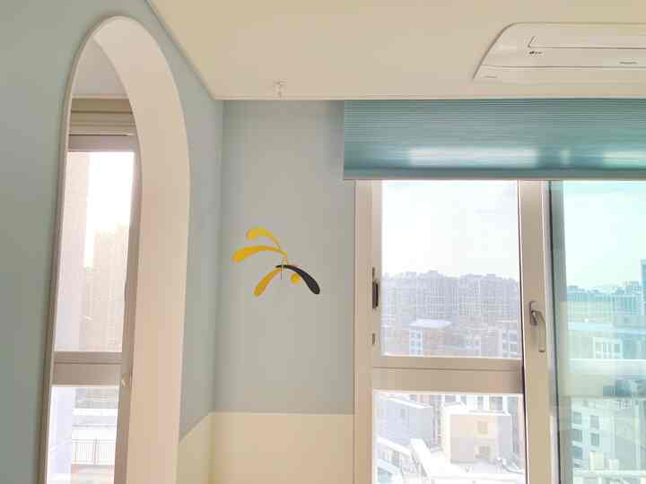 スカイブルーとアイボリーのツートーン壁紙とハニカムブラインドが配置された子供部屋、明るく落ち着いた雰囲気のインテリア