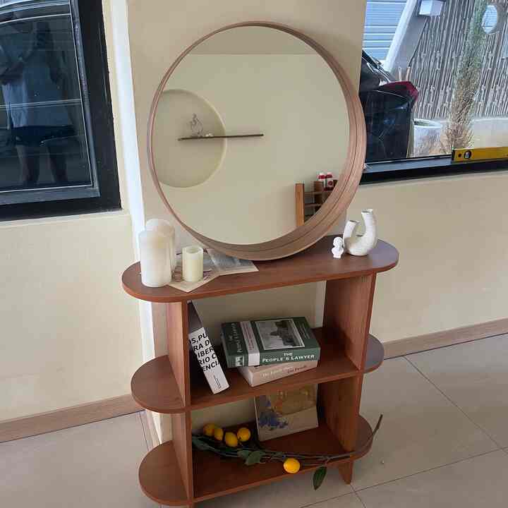 Natural color space featuring wooden bookshelf with a round mirror and various decorative objects in a cozy interior