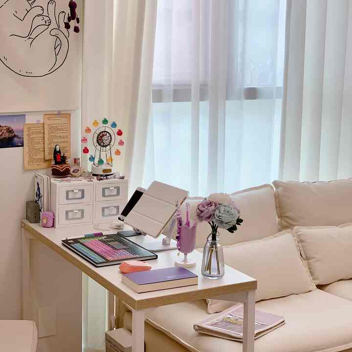 White and natural-toned studio home office featuring desk and fabric sofa in a cozy workspace