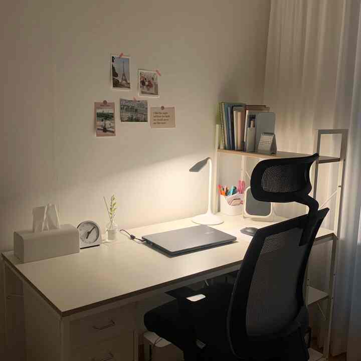 白を基調としたホームオフィス、シンプルなデスクとオフィスチェア、本棚が配置された落ち着いた雰囲気のインテリア
