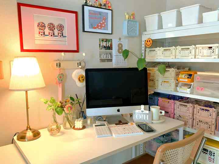 White and wood-tone compact home office featuring a neat desk with organized storage shelves creating a cozy space