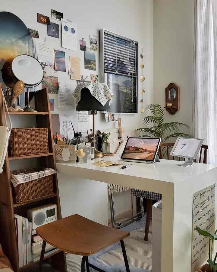白と木目調が調和した小さなホームオフィス、デスク上にはデジタル機器と装飾が置かれ、在宅勤務に適した雰囲気のあるインテリア