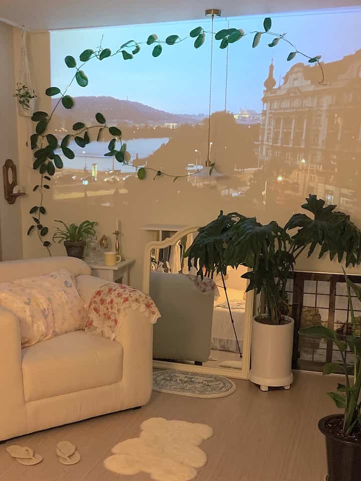 Cozy white and natural green living room featuring a comfortable sofa and mood-lit home cinema setup with plants