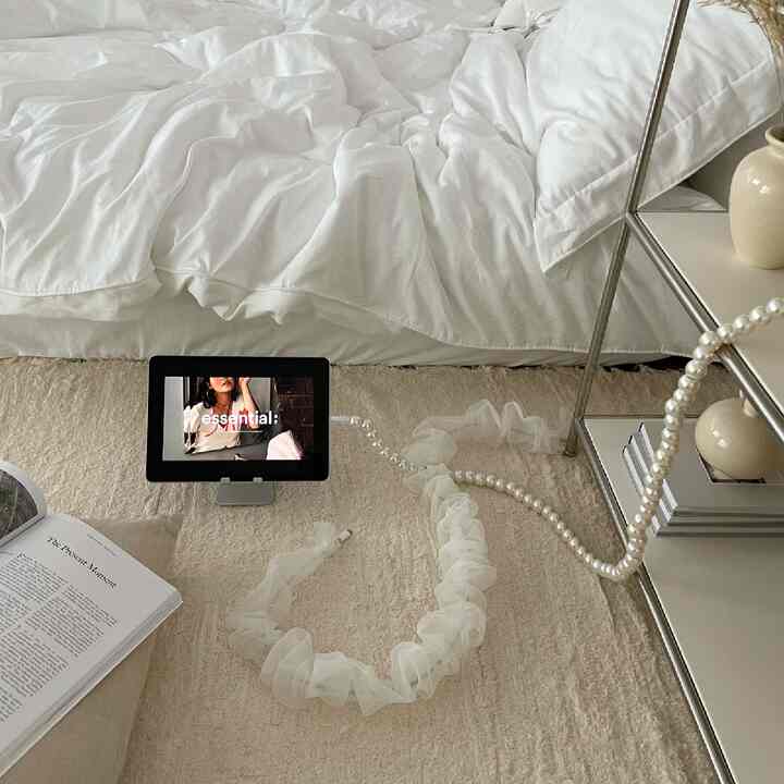 ナチュラルカラーの寝室、白い寝具とベージュのラグが配置された落ち着いた雰囲気のインテリア