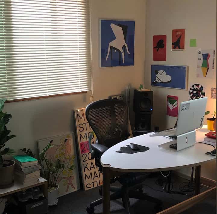 ホワイトとブラックのトーンでまとめられたワンルームの書斎兼ワークスペース、ノートパソコンとオフィスチェアが配置されたモダンでヴィンテージ感のあるインテリア