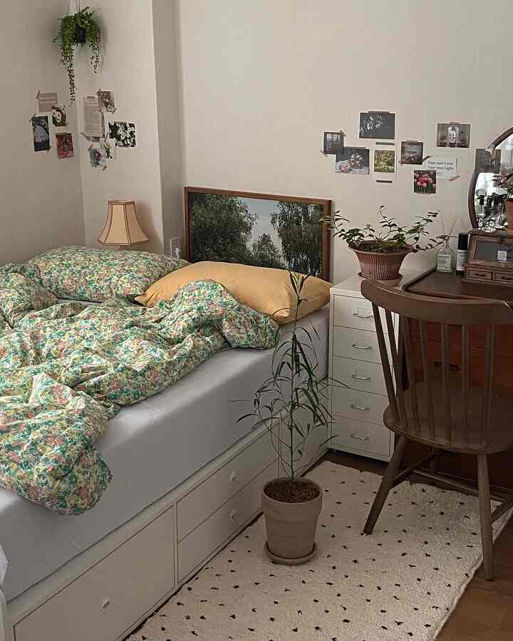 ホワイトトーンのコンパクトな寝室、ベッドと収納付きホワイトチェスト、木製デスクと植物が配置されたナチュラルな雰囲気のインテリア