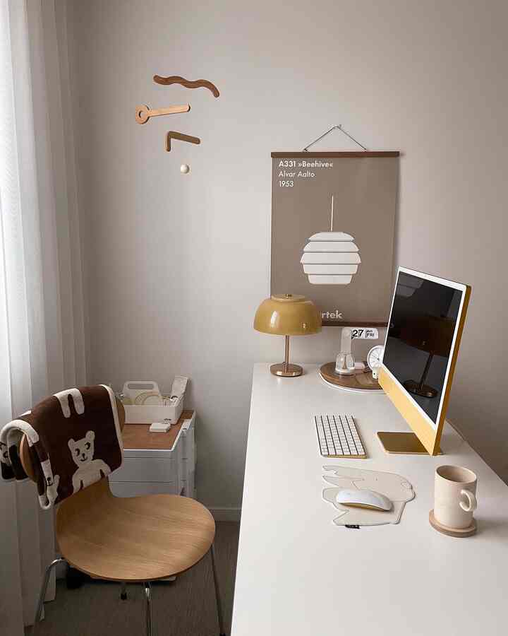 A modern study featuring a minimalist white desk and wood-tone chair with yellow accent elements