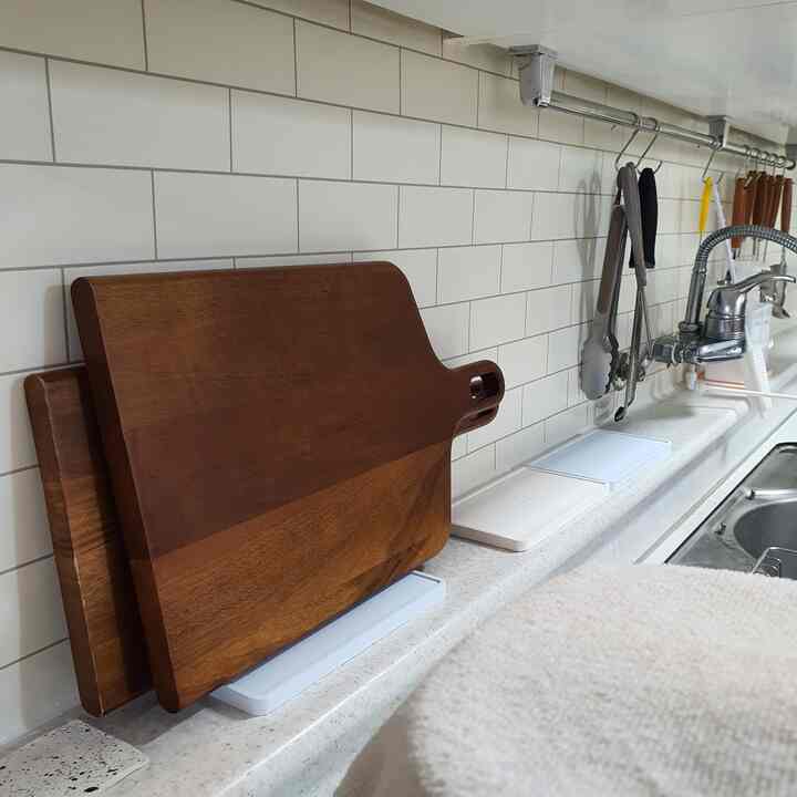 Natural-toned kitchen featuring wooden cutting boards and diatomaceous earth trays neatly arranged on a clean countertop