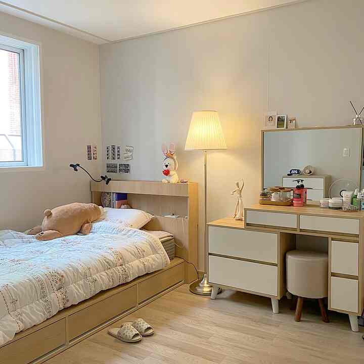 明るい木目調と白い壁が調和する居心地の良い寝室、ベッドと化粧台が配置された空間