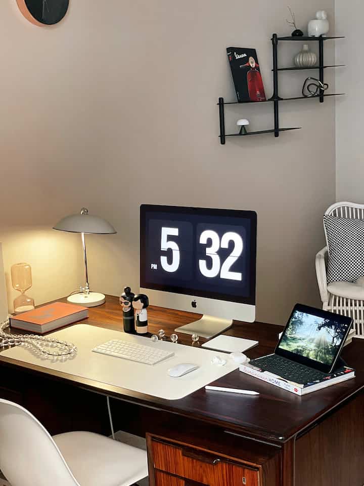 ベージュ調の壁と木製デスクが調和した1人用のホームオフィス書斎、iMacとiPadが置かれ、ミッドセンチュリーモダンスタイルの印象的なインテリア