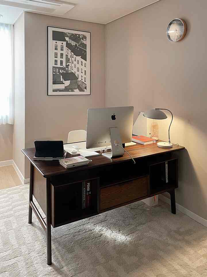 Beige mid-century modern home office with dark wood desk, iMac, and iPad Air arranged in a calm workspace