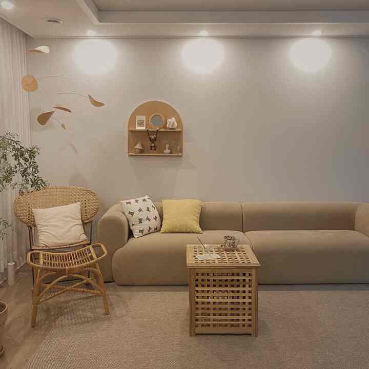 Natural brown-toned living room featuring beige sofa, rattan table, and stool with a cozy warm atmosphere