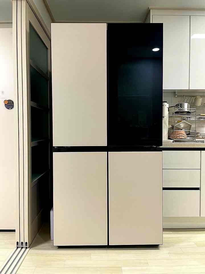 White and beige toned kitchen featuring LG Objet Collection refrigerator and neat countertop in a modern space